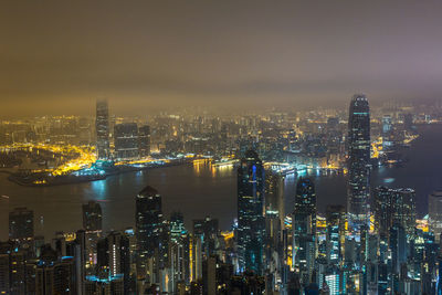 Illuminated cityscape against sky at night