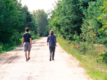 Rear view of father walking on footpath