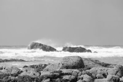 Scenic view of rocks on beach against sky