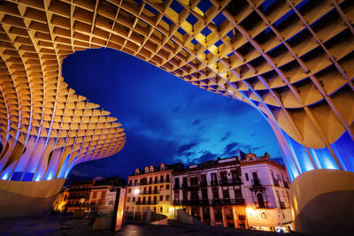 Low angle view of illuminated buildings against sky at night