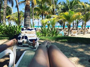 Low section of woman sitting by swimming pool