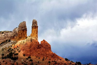 Low angle view of rock formation against cloudy sky