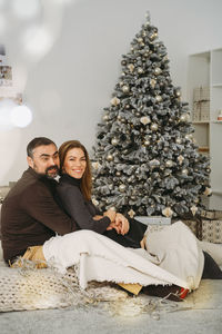 Happy couple celebrating romantic christmas eve at home. christmas interior decoration for family