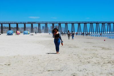 Full length rear view of woman walking on beach