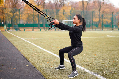 Full length of woman with arms raised in park