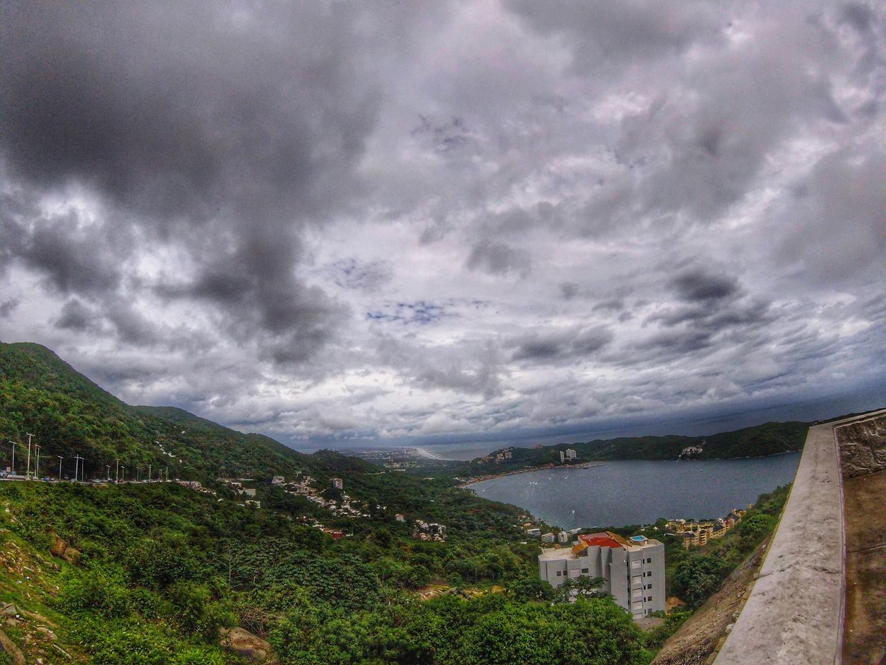 cloud - sky, sky, mountain, architecture, built structure, building exterior, building, overcast, nature, no people, scenics - nature, beauty in nature, storm, environment, city, tree, storm cloud, day, plant, mountain range, outdoors, ominous