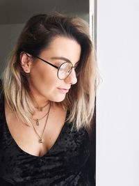 Close-up of woman standing by window at home