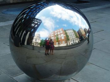 Full length of woman standing in city against cloudy sky