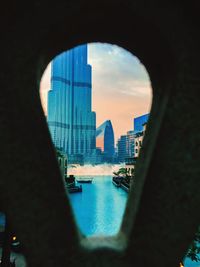 View of cityscape from river seen through arch