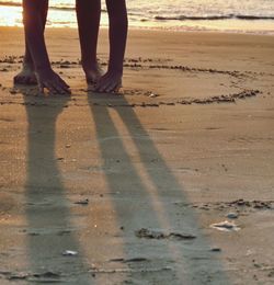 Low section of people standing on beach