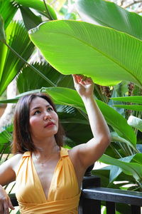 Woman looking at leaf in forest