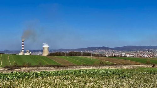 Panoramic view of factory field against sky