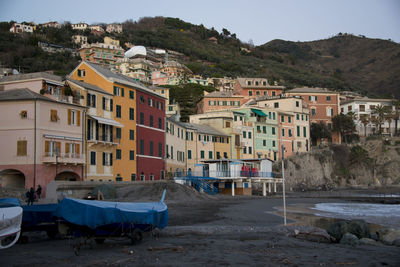 Buildings in town by sea against sky