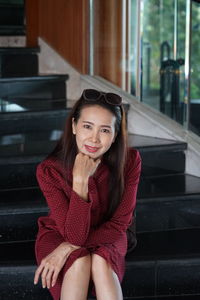 Portrait of smiling mature woman sitting on staircase