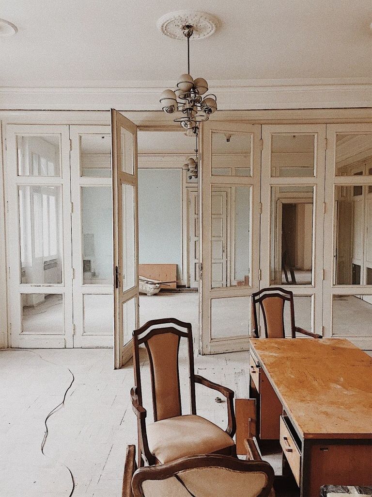 EMPTY CHAIRS AND TABLE IN ILLUMINATED ROOM