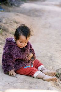 Baby hmong playing on dirty ground in chiang mai thailand