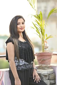 Portrait of young woman standing against wall