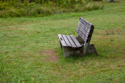Empty bench in field