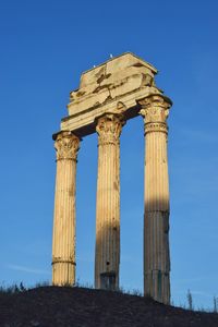 Low angle view of old ruins against blue sky