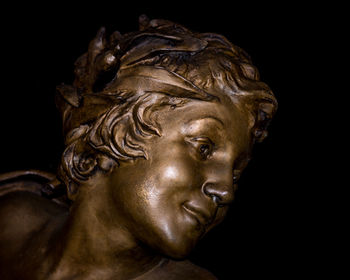 Close-up of statue over black background