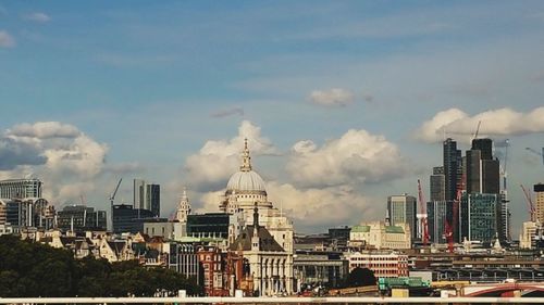 View of cityscape against cloudy sky