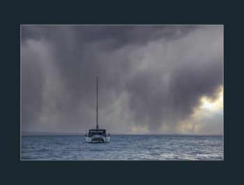 Sailboat sailing on sea against sky