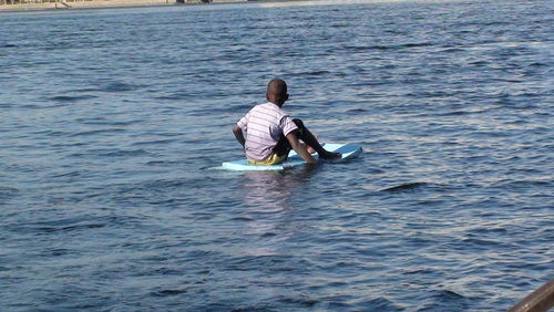 Rear view of man sitting in sea