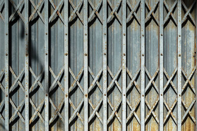 Full frame shot of closed metal fence against wall