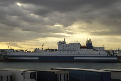 Pier by harbor against sky during sunset