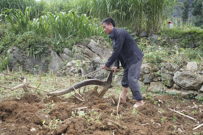 Side view of young man standing on field