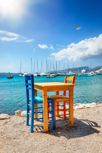 Deck chairs on beach against sky