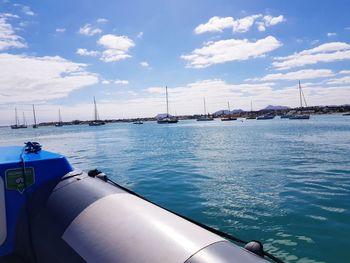 Sailboats moored on sea against sky