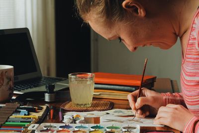 Side view of woman painting easter bunny