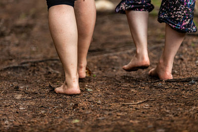 Low section of women walking in mud