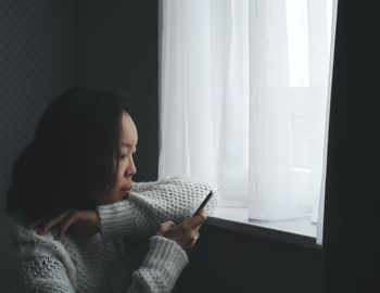 Woman sitting on book at home