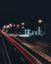 Light trails on road against sky at night