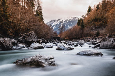 Scenic view of stream against sky during winter