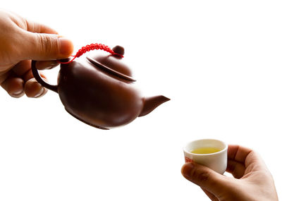 Midsection of woman holding coffee cup against white background