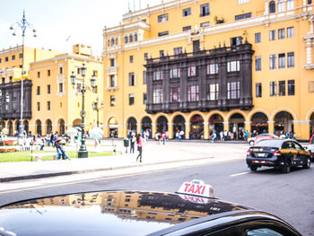 People on city street by buildings