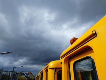 Yellow train against cloudy sky