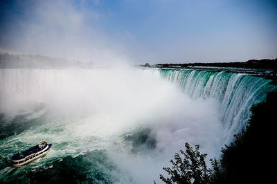 Scenic view of waterfall against sky