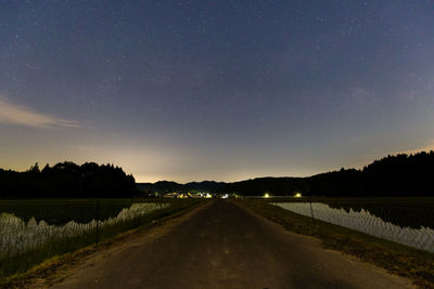 Road amidst landscape against sky at night