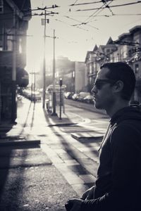 Side view of man looking at city street