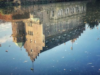 Reflection of building in puddle on street