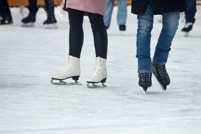 Low section of people walking on snow