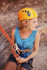 Smiling woman hanging on climbing rope during hiking