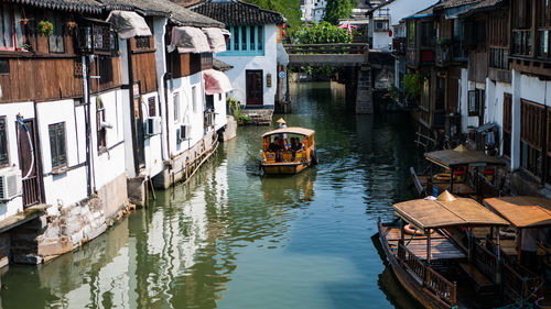 Boats in canal amidst buildings in city