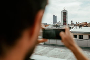 Man photographing cityscape through mobile phone