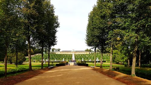 Footpath in park against sky