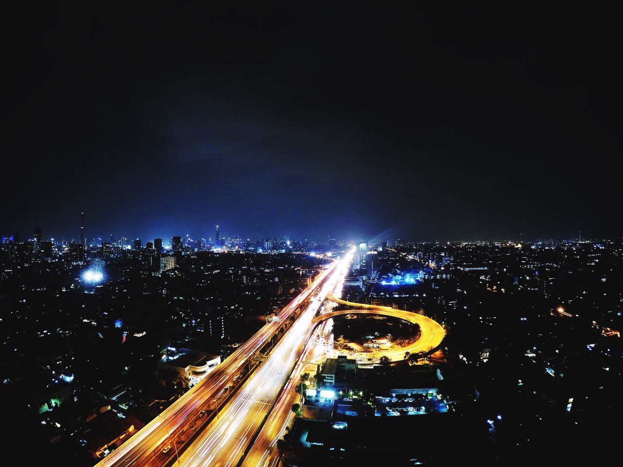 HIGH ANGLE VIEW OF LIGHT TRAILS ON ROAD IN CITY